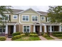 Charming two-story townhome featuring a welcoming front porch and well-maintained landscaping at 15693 Kinnow Mandarin Ln, Winter Garden, FL 34787