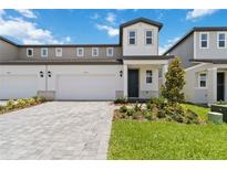 A well-manicured, modern two-story townhouse with a two-car garage and paver driveway at 1793 Archer Dr, Minneola, FL 34715