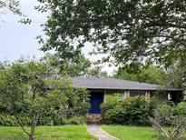 Charming one-story home with blue door, stone steps, and lush greenery at 201 Lyndhurst Ct, Longwood, FL 32779