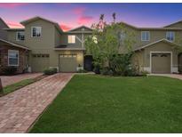 Beautiful two-story home with a well-manicured lawn and brick driveway at 2311 Chatham Place Dr, Orlando, FL 32824
