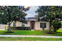 Charming single-story home with a well-manicured lawn and beautiful landscaping at 2555 Palmetto Ridge Cir, Apopka, FL 32712