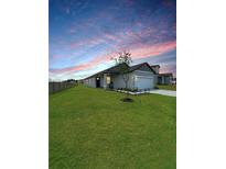 Beautiful single-story home with a well-manicured lawn at sunset at 2707 Virginia Pine Nw Dr, Bartow, FL 33830