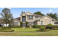 Inviting two-story home with stone accents, manicured lawn, fountain, and lush landscaping at 325 Green Ash Ln, Sanford, FL 32771