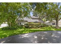 Charming home featuring lush landscaping and mature trees in a serene front yard setting at 4030 Cool Water Ct, Winter Park, FL 32792