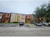 Multi-Gathering home with a parking lot and some lawn area with mature trees, creating a pleasant atmosphere at 5160 Conroy Rd # 1437, Orlando, FL 32811