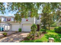 Charming two-story home featuring a two-car garage, brick driveway, and well-manicured landscaping at 5843 Strada Capri Way, Orlando, FL 32835