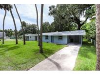 Charming single-story home features a carport and a long driveway surrounded by mature trees at 606 Washington St, Daytona Beach, FL 32114