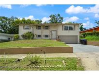 Two-story home with neutral paint, landscaped front yard, and attached one-car garage at 6416 Jackwood Ct, Orlando, FL 32818