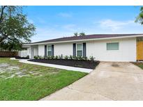 Charming single-story home featuring a freshly painted exterior, manicured lawn, and updated landscaping at 7440 Houston E Ct, Winter Park, FL 32792