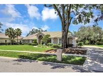 Stunning single-story home with manicured lawn and mature landscaping creating a welcoming curb appeal at 8623 Summerville Pl, Orlando, FL 32819