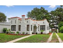 Charming home featuring stucco walls, a red roof, landscaped yard, and a quaint front entrance at 2021 University Dr, Orlando, FL 32804