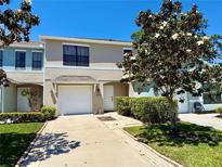 Charming townhome showcasing a well-manicured lawn and driveway, complemented by a flowering tree at 2120 Windsor Lake Cir, Sanford, FL 32773