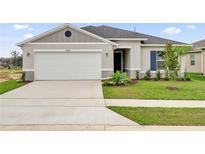 Charming single-story home with a well-manicured lawn, attached two-car garage, and inviting front entrance at 2644 Hancock Crossing Dr, Bartow, FL 33830