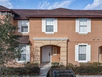 Charming two-story townhouse featuring a well-manicured front yard and classic white-trimmed windows at 2706 Bushman Dr, Kissimmee, FL 34746