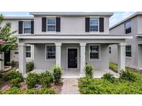 Charming front exterior featuring gray siding, dark shutters, and a welcoming covered porch at 3124 Addison Blvd, St Cloud, FL 34771