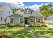 Charming craftsman home features a lush, green lawn and manicured landscaping around the front at 3226 Helen Ave, Orlando, FL 32804