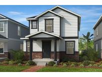 Charming two-story home with white siding, brick accents, and a well-manicured lawn with shrubs at 7212 Big Cedar Aly, Groveland, FL 34736