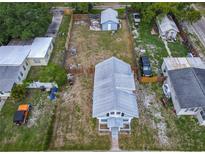 Aerial view of a two-story home with a large fenced backyard and additional storage buildings on the property at 1504 Indiana Ave, St Cloud, FL 34769