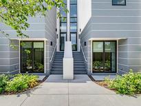 Modern townhouse exterior featuring a contemporary design, sleek lines, and inviting front entrances with landscaped greenery at 1760 Mondrian Cir, Winter Park, FL 32789
