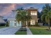 Modern two-story home with a brick and white facade, two-car garage, and a well-manicured lawn at 1781 Pine Ave, Winter Park, FL 32789