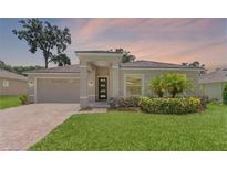 Charming single-story home featuring a well-manicured lawn and attached two-car garage at 1812 Stoneywood Way, Apopka, FL 32712