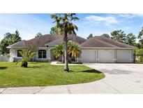 Charming single-story home with a well-manicured lawn, mature palm trees, and a three-car garage at 19562 Majestic St, Orlando, FL 32833