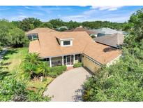 Charming home with a tan exterior, brick paver driveway, and lush landscaping at 217 Lake Cassidy Dr, Kissimmee, FL 34759