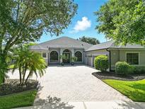 Well maintained home with a paver driveway, arched windows, and nicely manicured landscaping at 2308 Bur Oak Ct, Oviedo, FL 32766