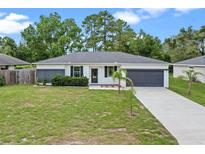Charming single-story home features a well-manicured lawn, attached garage, and fresh landscaping at 2626 Coachman Dr, Deltona, FL 32738