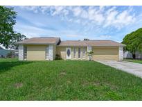 Charming single-story home with a well-maintained lawn, a front-facing garage, and decorative stone accents at 300 Florida Pkwy, Kissimmee, FL 34743