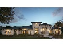 Elegant exterior view of a two-story home with manicured lawn and meticulously landscaped front yard at 3428 Chaine Du Lac Blvd, Windermere, FL 34786