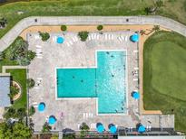 Aerial view of the large community pool featuring plenty of lounge chairs and tables with umbrellas at 3944 Atrium Dr # 4, Orlando, FL 32822