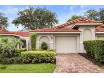 Charming home featuring a red tile roof, two-car garage, and lush landscaping at 7528 Chapelhill Dr, Orlando, FL 32819