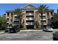 Beautiful multi-story building featuring tropical landscaping and a convenient parking area at 7651 Whisper Way # 201, Kissimmee, FL 34747