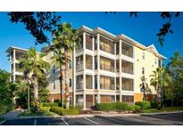 Condo exterior showcasing multiple stories with screened-in balconies and lush landscaping at 9051 Treasure Trove Ln # 505, Kissimmee, FL 34747