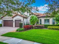 Charming home featuring a three-car garage, lush landscaping, and a tile roof at 9942 Hatton Cir, Orlando, FL 32832