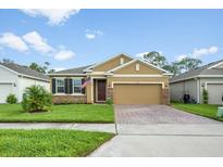 Charming single-story home featuring manicured lawn, brick accents, and a paved driveway leading to a two-car garage at 1027 Eagle Tree Ln, Sanford, FL 32771