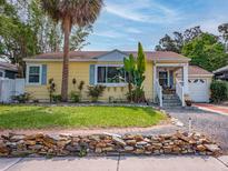 Charming yellow bungalow with a stone-lined garden and inviting front porch at 1041 N Fern Creek Ave, Orlando, FL 32803