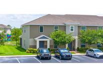 Inviting two-story townhome with neutral siding, landscaped grounds, and convenient parking at 130 Claire Ln, Davenport, FL 33837