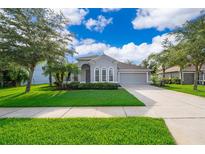 Charming single-Gathering home with well-manicured lawn, mature trees, and a two-car garage at 1415 Ellis Fallon Loop, Oviedo, FL 32765