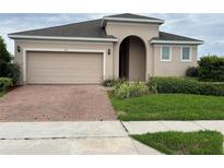 Charming single Gathering home with a two-car garage and brick paver driveway at 147 Seville Dr, Davenport, FL 33837