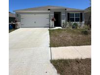 Charming single-story home with a well-maintained lawn and two-car garage at 1727 Buckeye Rd, Davenport, FL 33837