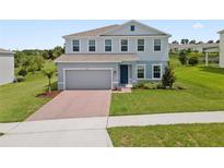 Charming two-story home with a brick driveway and well-manicured lawn offers a welcoming curb appeal at 2168 Aibonito Cir, Clermont, FL 34711