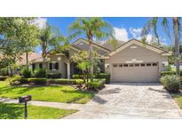 Charming single-story home featuring a two car garage, tiled roof, lush landscaping, and a paved driveway at 3307 Kentshire Blvd, Ocoee, FL 34761