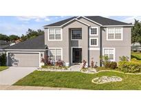 Charming two-story home with landscaped yard, black roof, neutral paint and two car garage at 3824 Blue Dasher Dr, Kissimmee, FL 34744