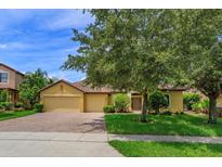 Charming home with well-maintained landscaping, brick driveway, and a two-car garage at 3904 Coastal Breeze Dr, Kissimmee, FL 34744
