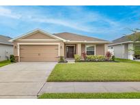 Charming single-story home featuring a well-manicured lawn, neutral color palette, and attached two-car garage at 5416 Tessin Trl, St Cloud, FL 34771