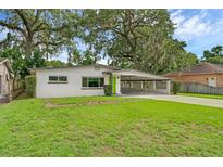 Charming single story home with white painted brick and green door, complimented by mature landscaping at 714 28Th St, Orlando, FL 32805