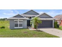 Charming single-story home features a well-maintained lawn, a gray exterior, and a spacious two-car garage at 7744 Country Run Pkwy, Orlando, FL 32818