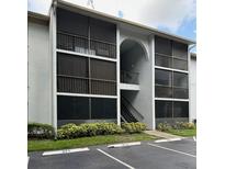 Exterior view of building with screened in patios, parking, and landscaped bushes at 8211 Sun Spring Cir # 11, Orlando, FL 32825